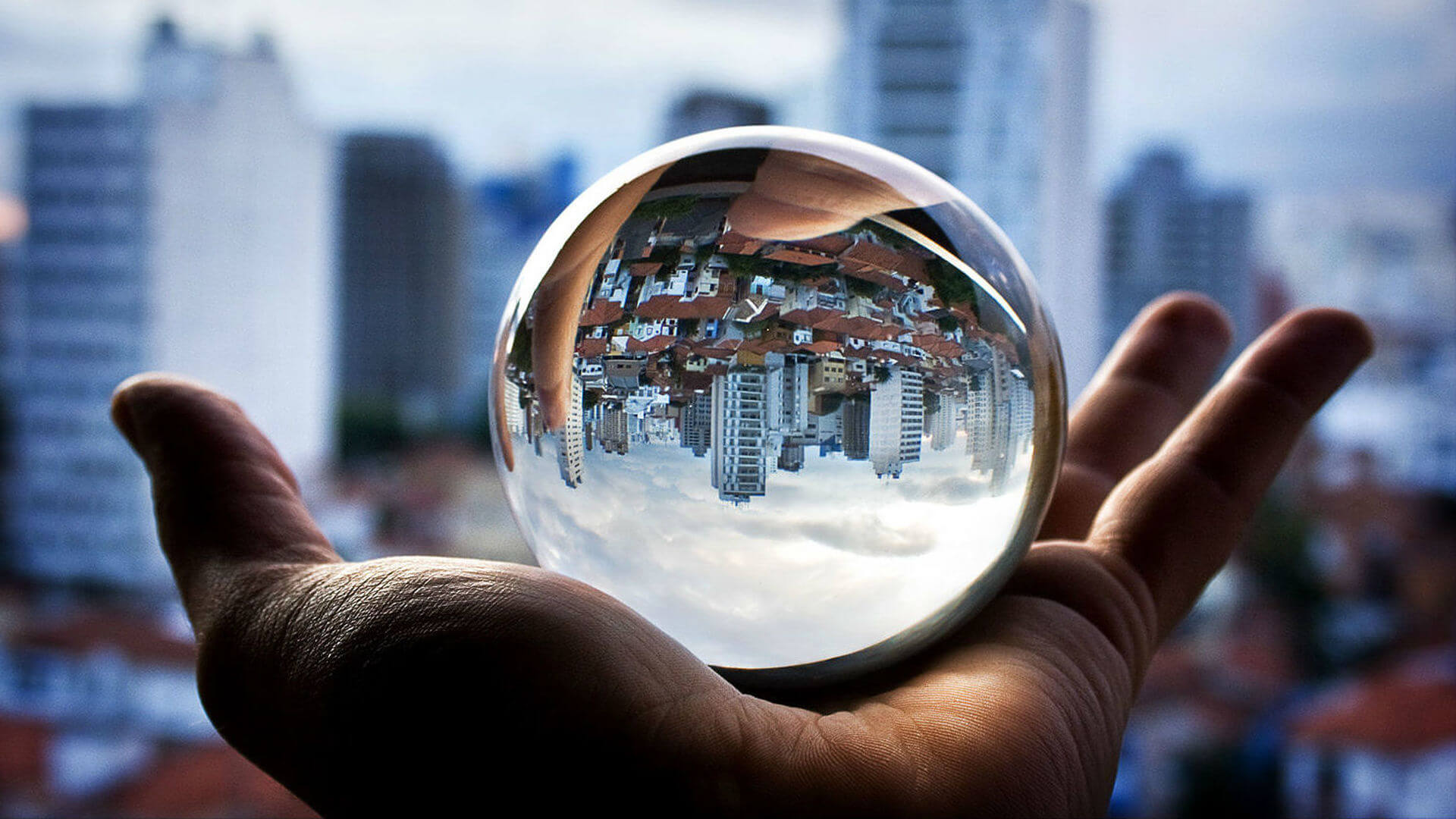 Изменение в жизни городов. Мир меняется. Стеклянный шар в руке. Заглянуть в будущее. Видеть будущее.